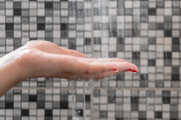 istock Soft selective focus of hands and droplets of water from shower with pattern background 1094098652