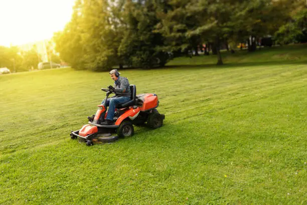 Photo of man drives a lawnmower