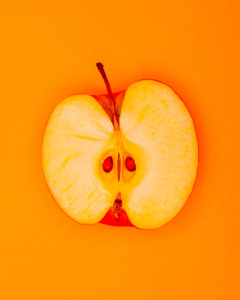 istock Funky Half an Apple pop Art style centred from above on plain orange background 1094100552