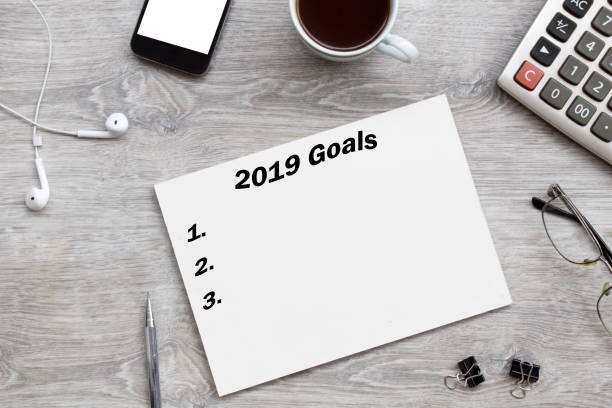 istock 2019 goals list with paper, cup of coffee over on gray background. 1094101250
