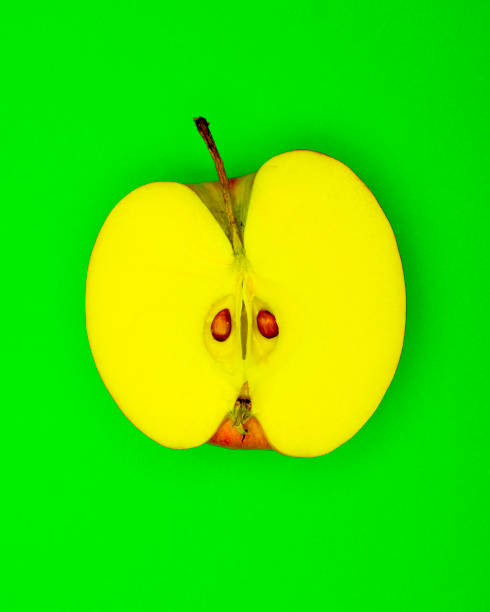 istock Funky Half an yellow Apple pop Art style centred from above on plain green background 1094101406