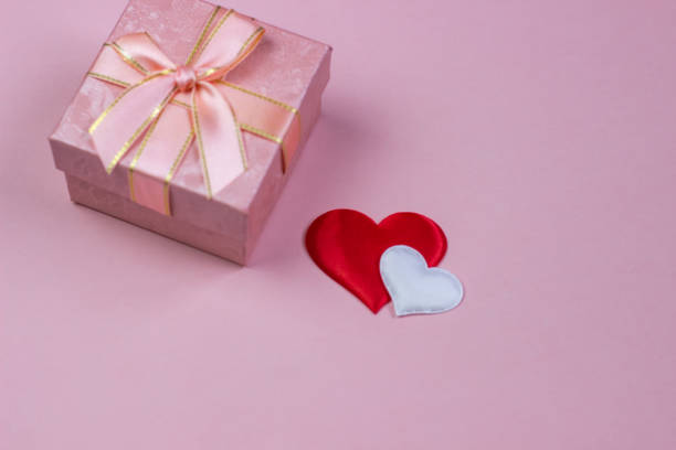 istock A gift in a beautiful box and hearts red and white on a pink background. Valentine's Day, International Women's Day. 1094101792