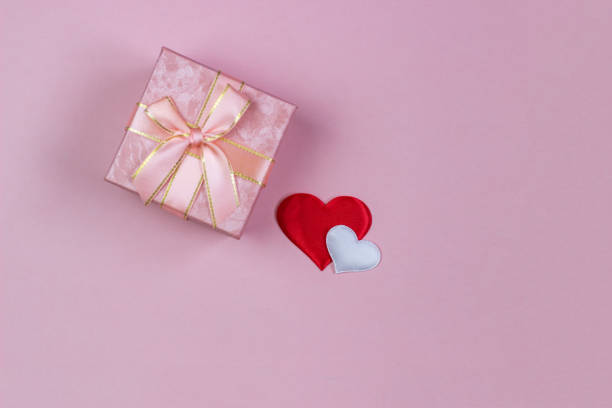 istock A gift in a beautiful box and hearts red and white on a pink background. Valentine's Day, International Women's Day. 1094101796