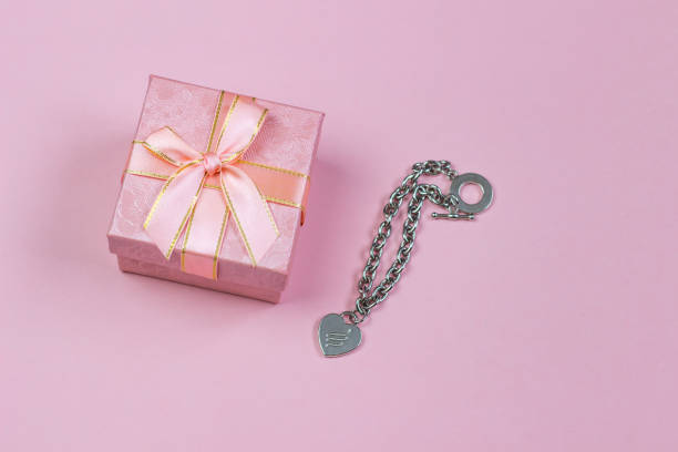 istock A gift in a beautiful box and a necklace with a heart on a pink background. Valentine's Day, International Women's Day. 1094101802