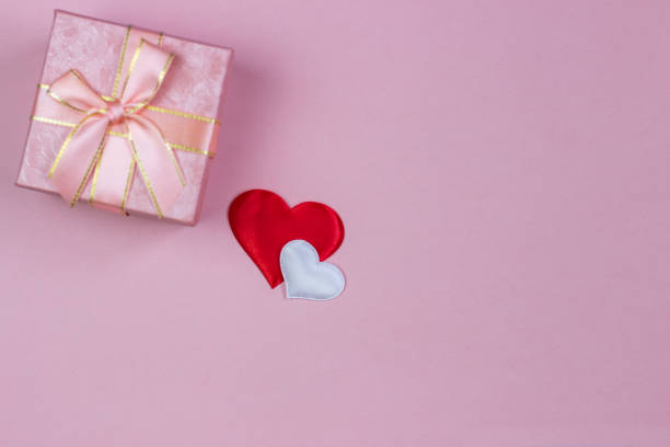 istock A gift in a beautiful box and hearts red and white on a pink background. Valentine's Day, International Women's Day. 1094101806