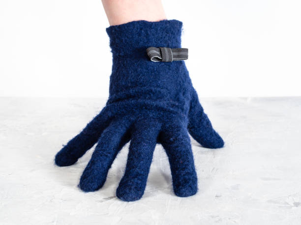 hand in blue glove with bow tie leans on board