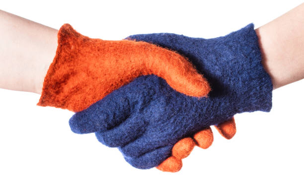 istock handshake of two hands in blue and orange gloves 1094103782