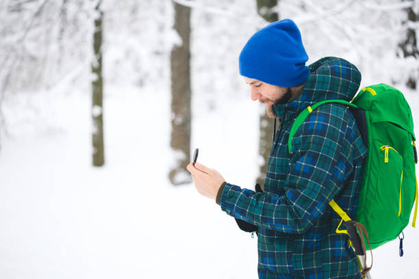 mann suche richtung mit kompass im verschneiten winterwald - orienteering planning mountain climbing compass stock-fotos und bilder