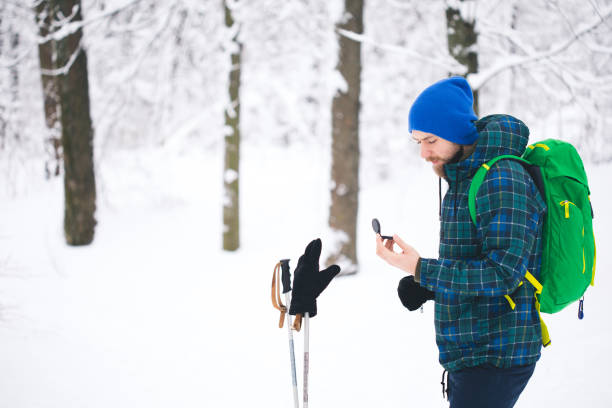 человек ищет направление с компасом в зимнем снежном лесу - orienteering planning mountain climbing compass стоковые фото и изображения