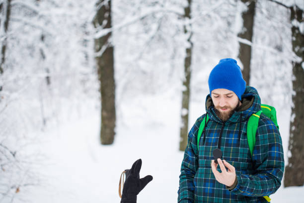человек ищет направление с компасом в зимнем снежном лесу - orienteering planning mountain climbing compass стоковые фото и изображения