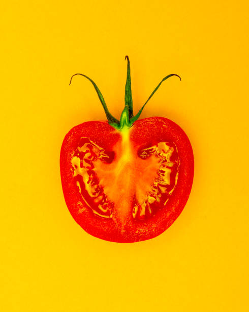 istock Single Half Salad Tomato with stalk pop Art style centred from above on bright yellow plain background 1094105556