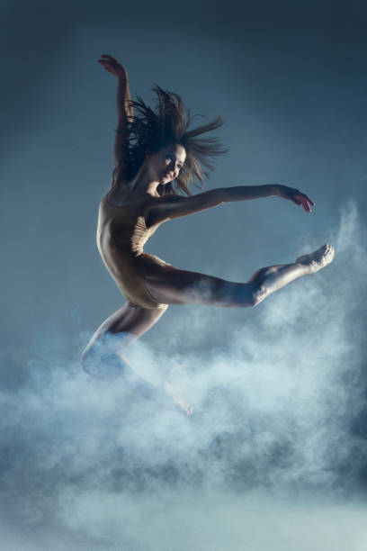 istock Muscle woman dancer dancing with smoke on isolated background 1094117258