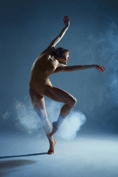 istock Muscle woman dancer dancing with smoke on isolated background 1094117520