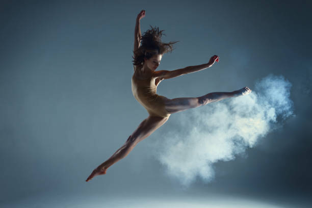 istock Muscle woman dancer dancing with smoke on isolated background 1094117572