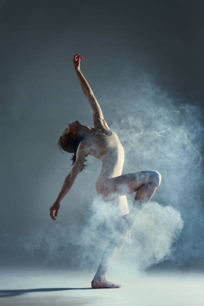 istock Muscle woman dancer dancing with smoke on isolated background 1094118254