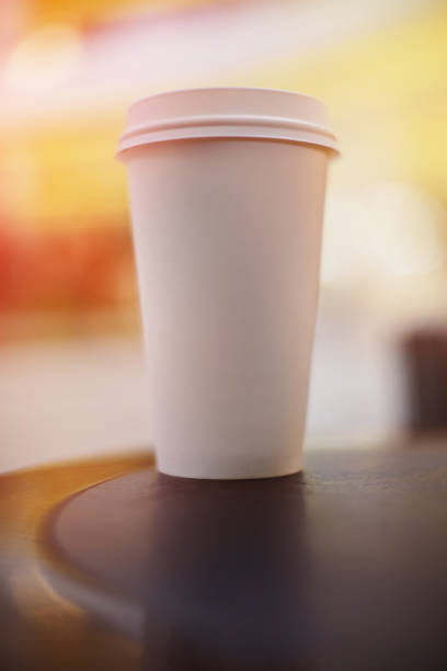 istock Disposable single take-out paper coffee cup. Shallow depth of field, blurry background 1094118902