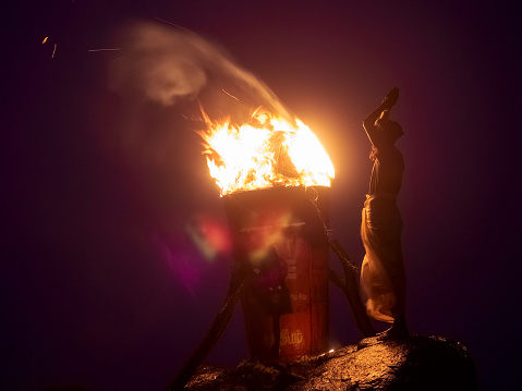 India, Tamil Nadu, Tiruvannamalai December 08, 2014: Festival Kardigay Dipam on Mount Arunachala. Night. A man prays standing in front of a sacred fire