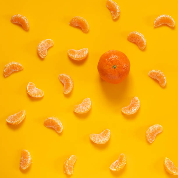 istock Whole tangerine and slices on yellow 1094123174