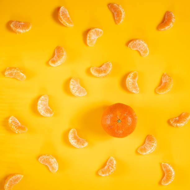 istock Whole tangerine and slices on yellow 1094123188