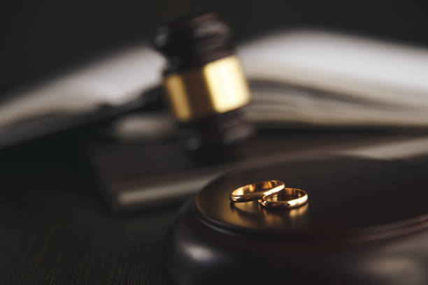 wedding rings on the figure of a broken heart from a tree, hammer of a judge on a wooden background. divorce proceedings - divórcio imagens e fotografias de stock