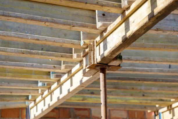 istock Formwork construction concept. Low angle top view photo of wooden beam on support pipes inside unfinished building 1094147880