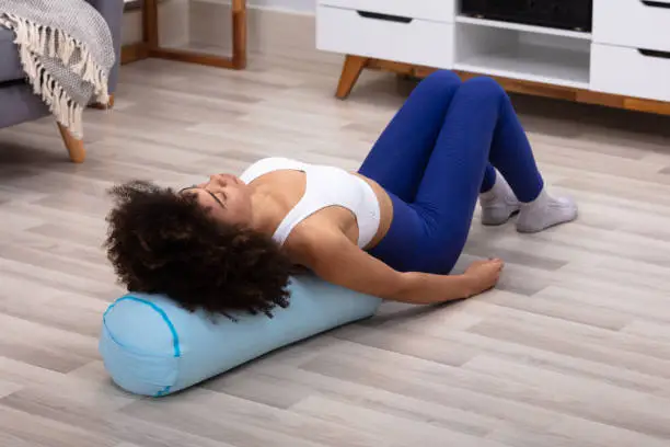 Close-up Of A Young African Woman Lying On Pillow Exercising