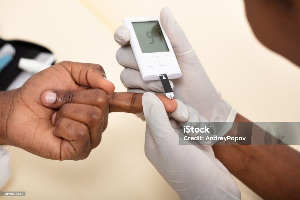 Doctor Checking Patient's Blood Sugar Level With Glucometer Close-up Of Female Doctor Checking Patient's Blood Sugar Level With Glucometer In Clinic Adult Stock Photo