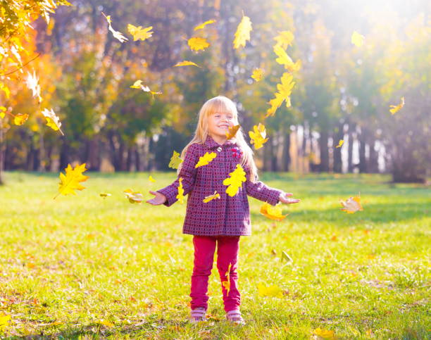 istock Girl, garden, autumn, falling leaves 1094163108