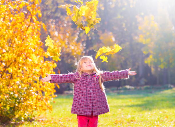 istock Girl, garden, autumn, falling leaves 1094163154