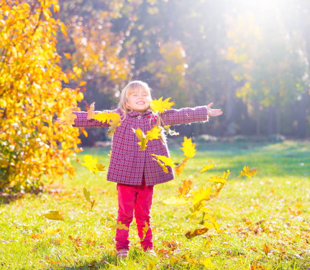 istock Girl, garden, autumn, falling leaves 1094163364