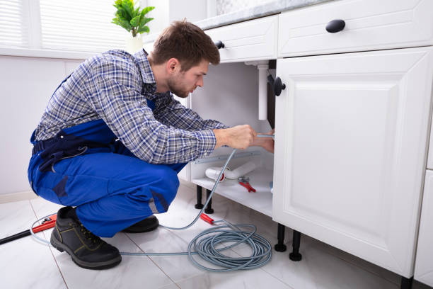 Plumber Cleaning Clogged Sink Pipe Young Male Plumber Cleaning Clogged Sink Pipe In Kitchen drainage photos stock pictures, royalty-free photos & images