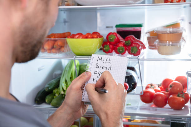 istock Person's Writing On Diary Near Refrigerator 1094164684