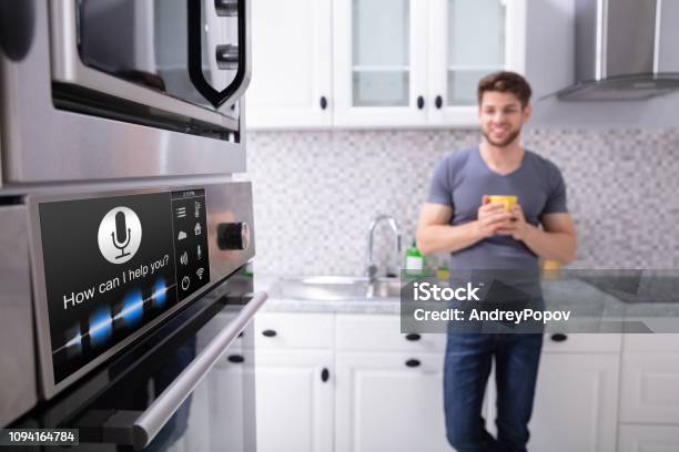 Man Looking At Ofen Mit Spracherkennung Stockfoto und mehr Bilder von Intelligenz - Intelligenz, Haushaltsmaschine, Küche