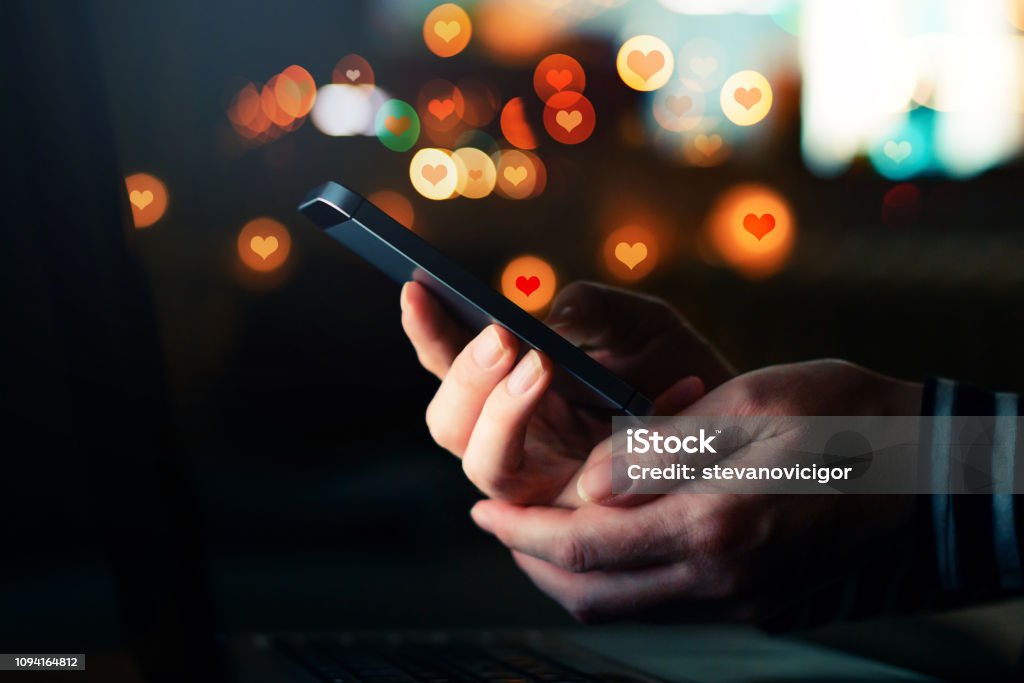 Social media likes for Valentine's day Social media likes for Valentine's day, conceptual image of female hands holding smartphone Social Media Stock Photo