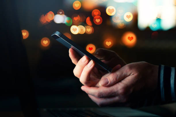 Social media likes for Valentine's day Social media likes for Valentine's day, conceptual image of female hands holding smartphone heart emoji phone stock pictures, royalty-free photos & images