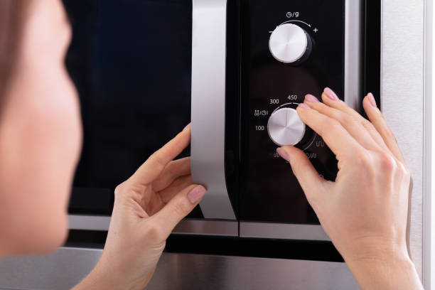 istock Woman Adjusting Temperature Of Microwave Oven 1094167298