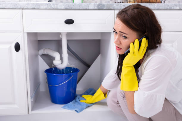 istock Woman Calling Plumber In Front Of Water Leaking From Pipe 1094170720