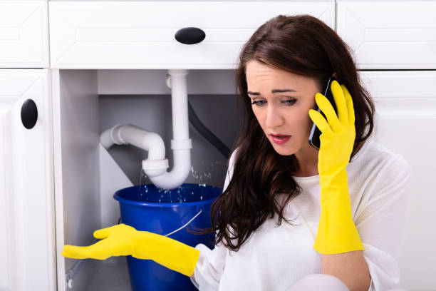 istock Woman Calling Plumber In Front Of Water Leaking From Pipe 1094170736
