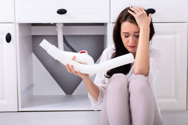 istock Upset Woman Holding Sink Pipe 1094170758