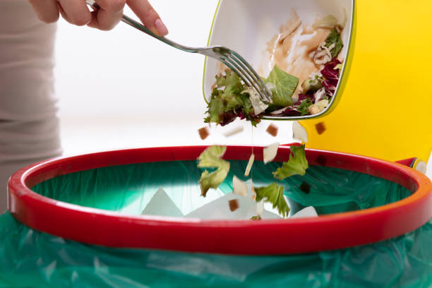 istock Woman Throwing Vegetables In Trash Bin 1094170870