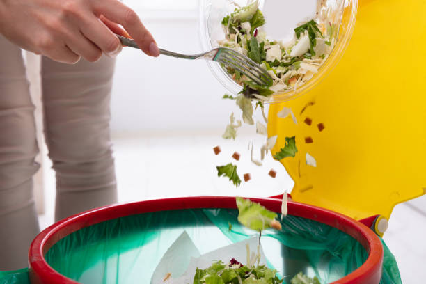 istock Woman Throwing Vegetables In Trash Bin 1094170878