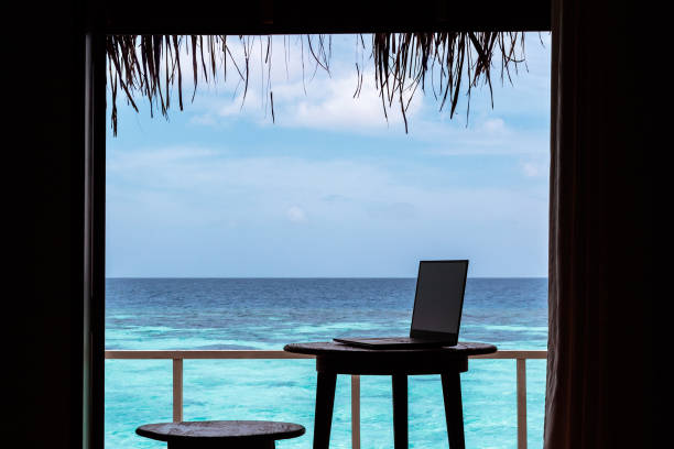 istock silhouette of a computer on a table. Clear blue tropical water as background 1094171214