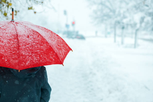 istock Woman under red umbrella in snow 1094171266