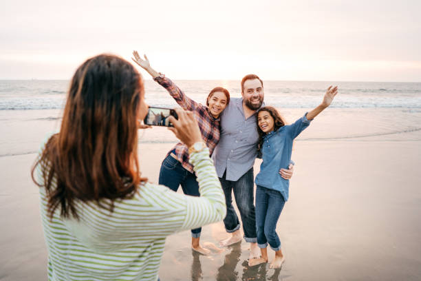 istock Family on the beach taking photos 1094171380