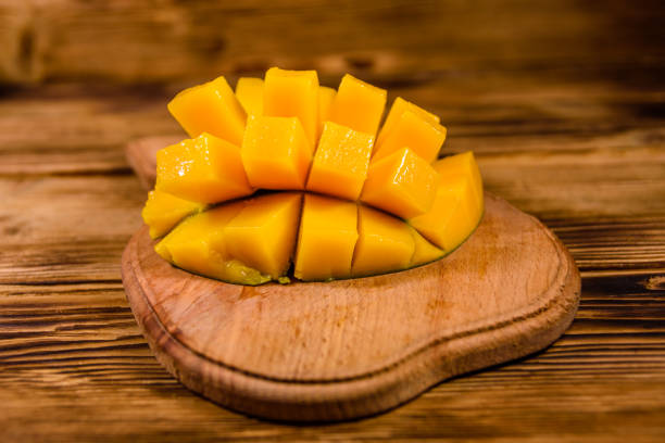 istock Cutting board with chopped mango fruit on a wooden table 1094183234