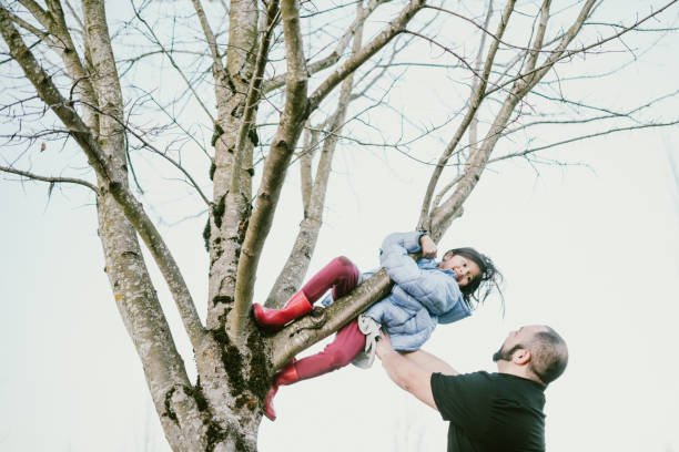 istock Loving Hispanic Father Helps Daughter Climb Tree 1094191386