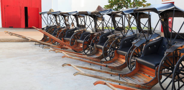 Transportation, Asian Thai Traditional man drawn vintage carriages or pulled rickshaws (ricksha, jinriksha), mode of human-powered transport by which a runner draws two-wheeled cart which seats people
