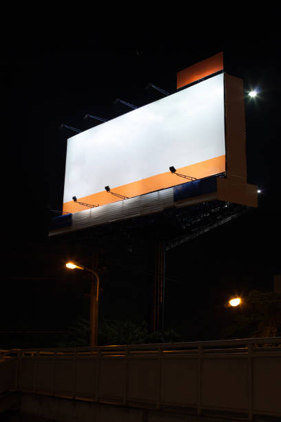 istock empty advertisement billboard with white blank space background at night above the pedestrian bridge across main road. Advertising, Outdoor Media, Out of Home Communication, Mass Info Display concept 1094199358