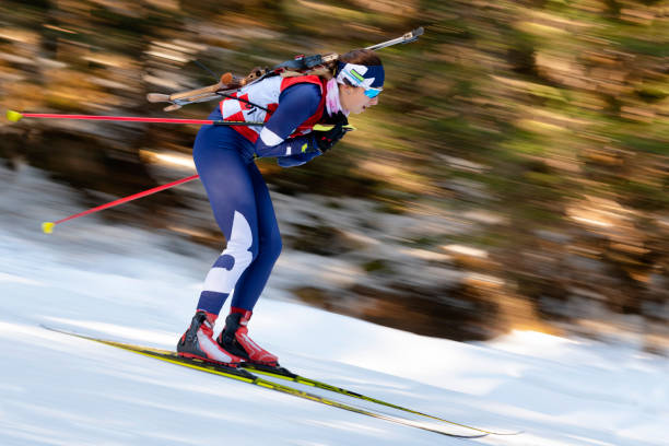 side view of female biathlon competitor at cross-country skiing, motion blurred - biathlon imagens e fotografias de stock