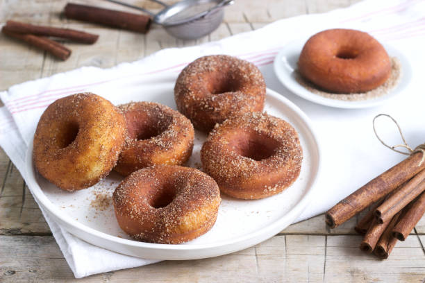 istock Homemade donuts with sugar and cinnamon on a wooden background. Rustic style. 1094204518